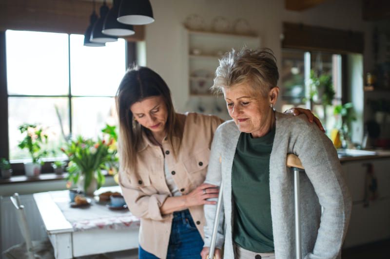 In home caregiver helping a senior to kitchen