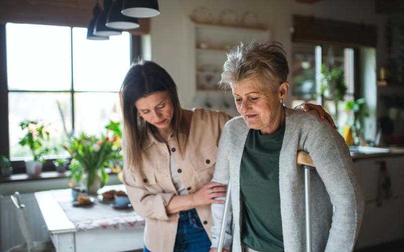 In home caregiver helping a senior to kitchen